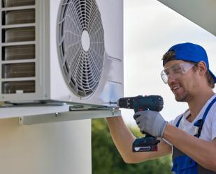 Un installateur pose une pompe à chaleur