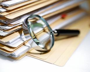 Une loupe sur des dossiers représentant des contrôles