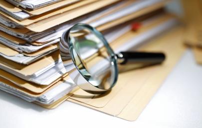 Une loupe sur des dossiers représentant des contrôles